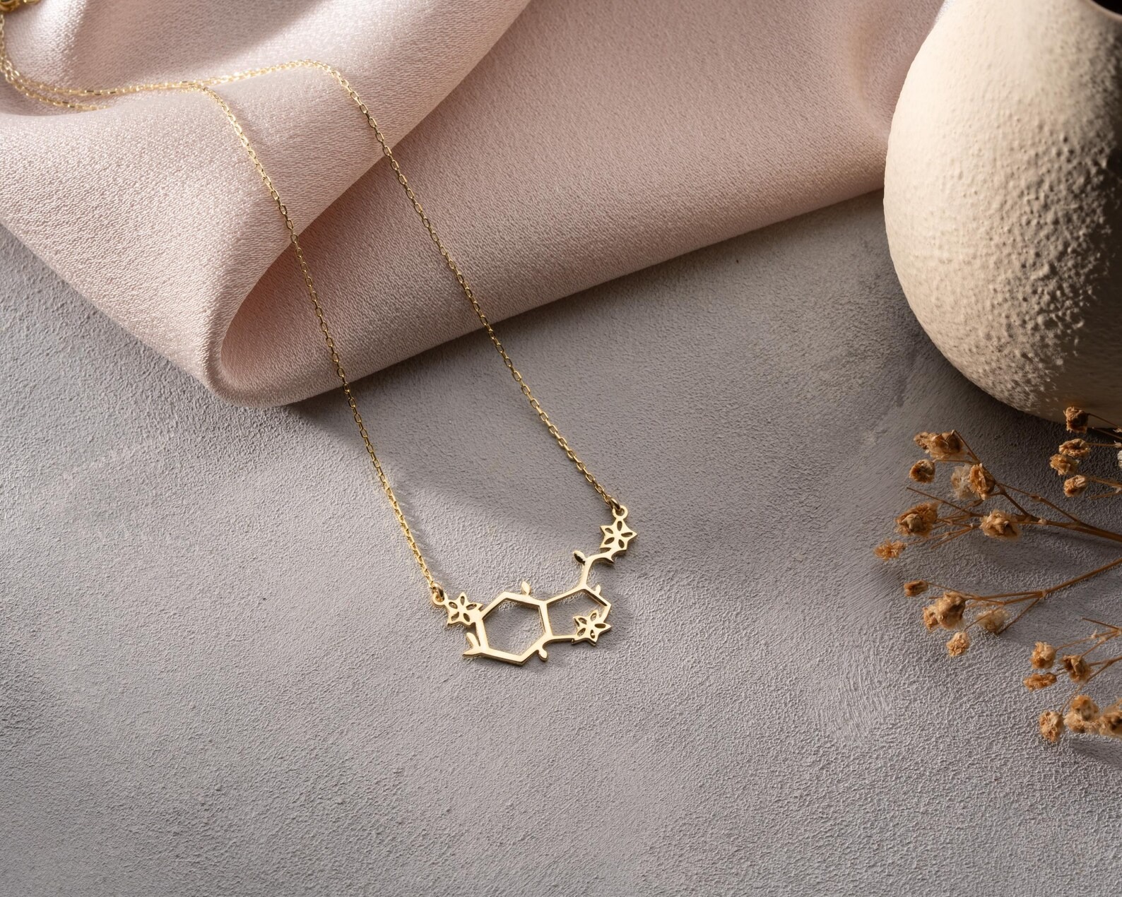 Pozlátený náhrdelník molekuly serotonínu s kvetinovými detailmi